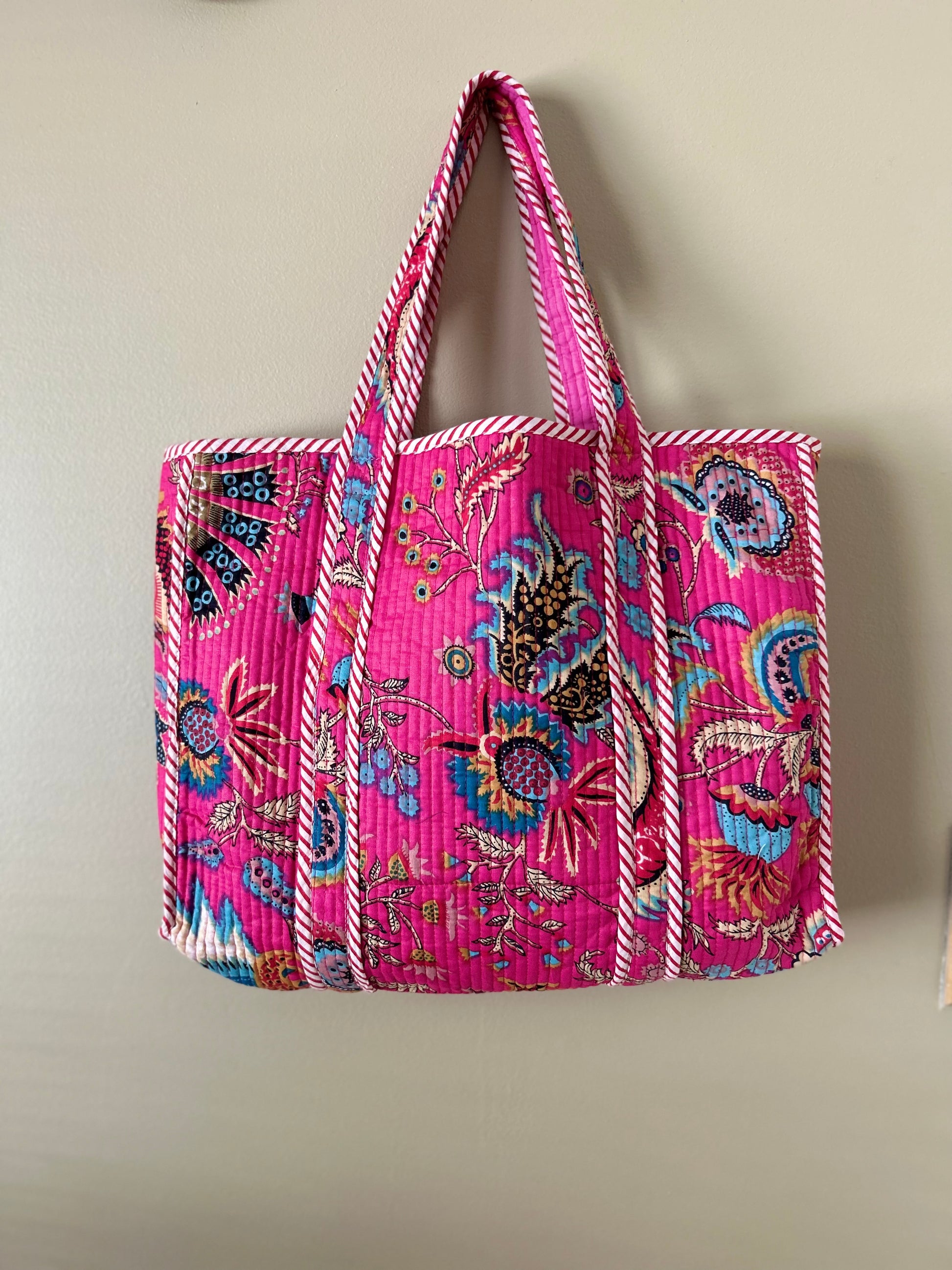 Collection of hand block printed quilted tote bags, showcasing traditional craftsmanship and contemporary designs. Available in five prints and colors: Indigo Neel, Peach Plumari, Pink Blossom, Grey Flora, and Teal Boota. Practical, spacious, and made from breathable fabrics. Support sustainable practices and empower artisans. Elevate your style with these artistic tote bags. Shop now and embrace the beauty of hand block printing.