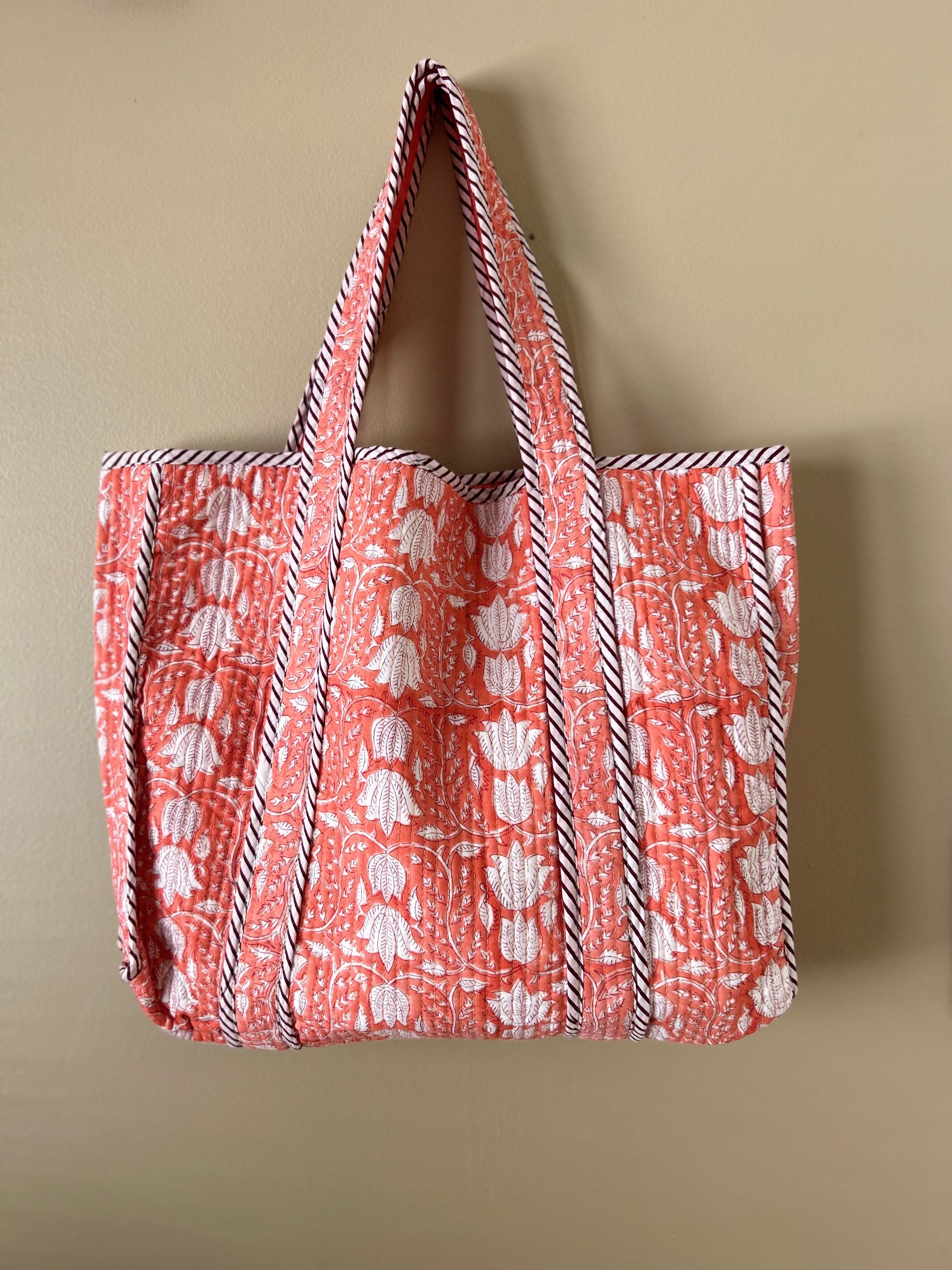 Collection of hand block printed quilted tote bags, showcasing traditional craftsmanship and contemporary designs. Available in five prints and colors: Indigo Neel, Peach Plumari, Pink Blossom, Grey Flora, and Teal Boota. Practical, spacious, and made from breathable fabrics. Support sustainable practices and empower artisans. Elevate your style with these artistic tote bags. Shop now and embrace the beauty of hand block printing.