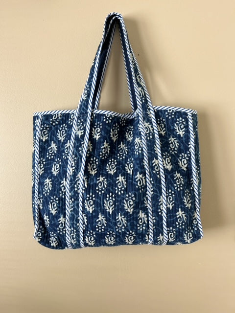 Collection of hand block printed quilted tote bags, showcasing traditional craftsmanship and contemporary designs. Available in five prints and colors: Indigo Neel, Peach Plumari, Pink Blossom, Grey Flora, and Teal Boota. Practical, spacious, and made from breathable fabrics. Support sustainable practices and empower artisans. Elevate your style with these artistic tote bags. Shop now and embrace the beauty of hand block printing.